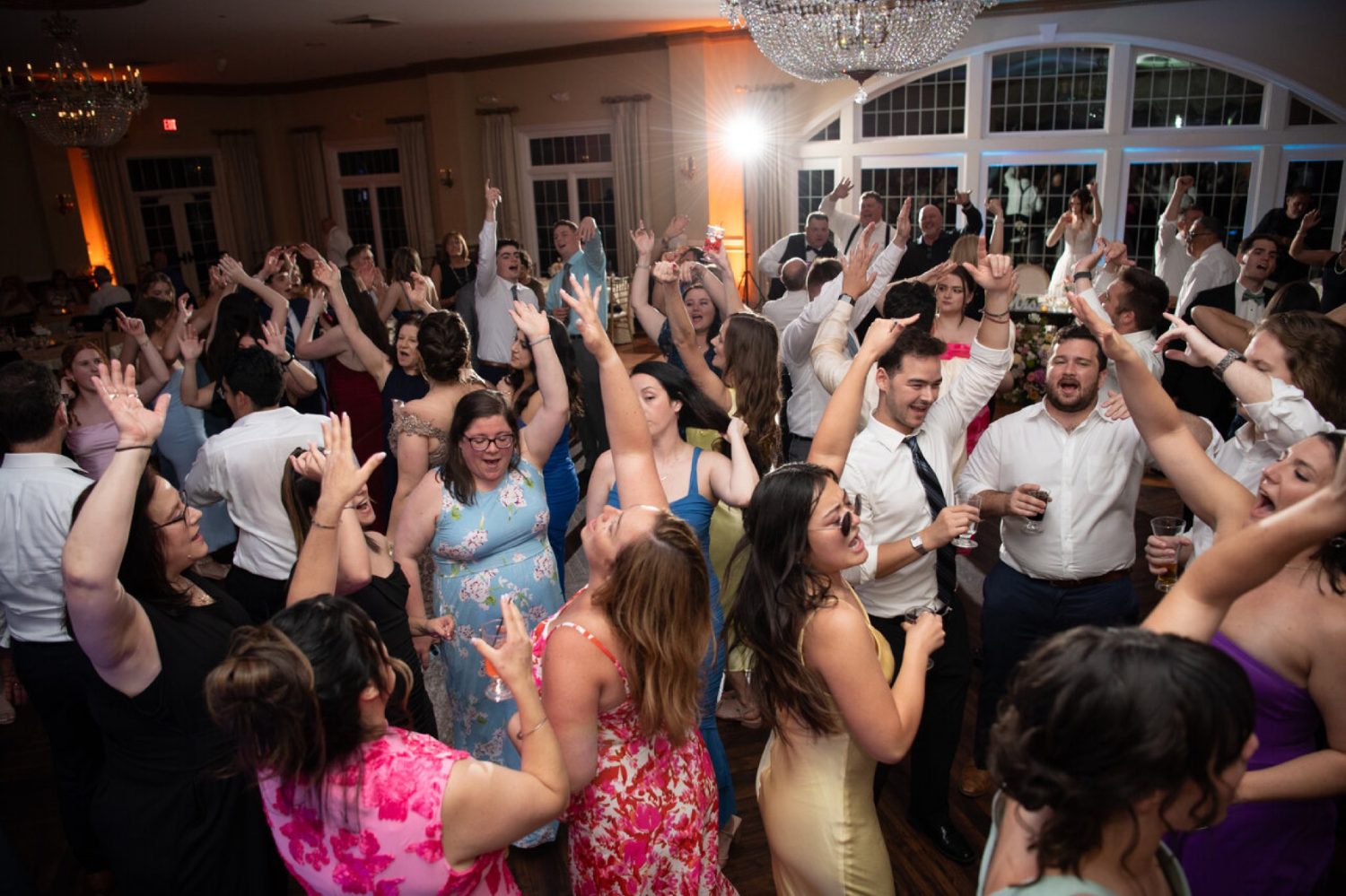 Packed dance floor with guests' hands up at an Accent Event Group wedding