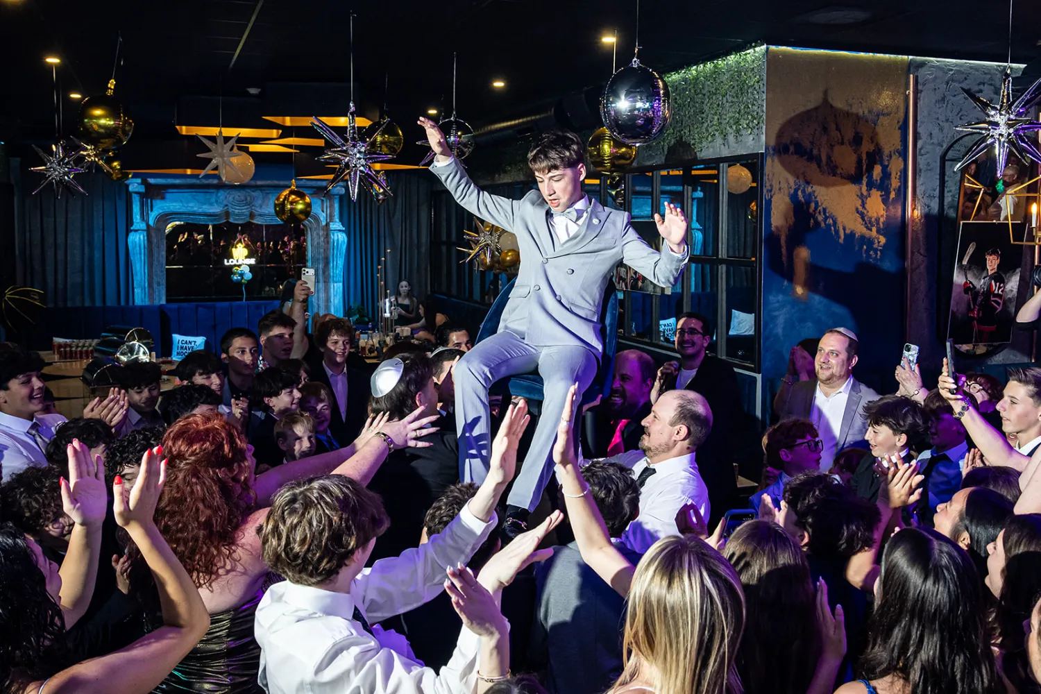 Guests lifting the guest of honor on a chair during the hora